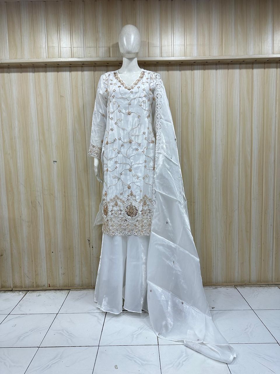 white embroidered dress with a matching dupatta on a mannequin against a striped