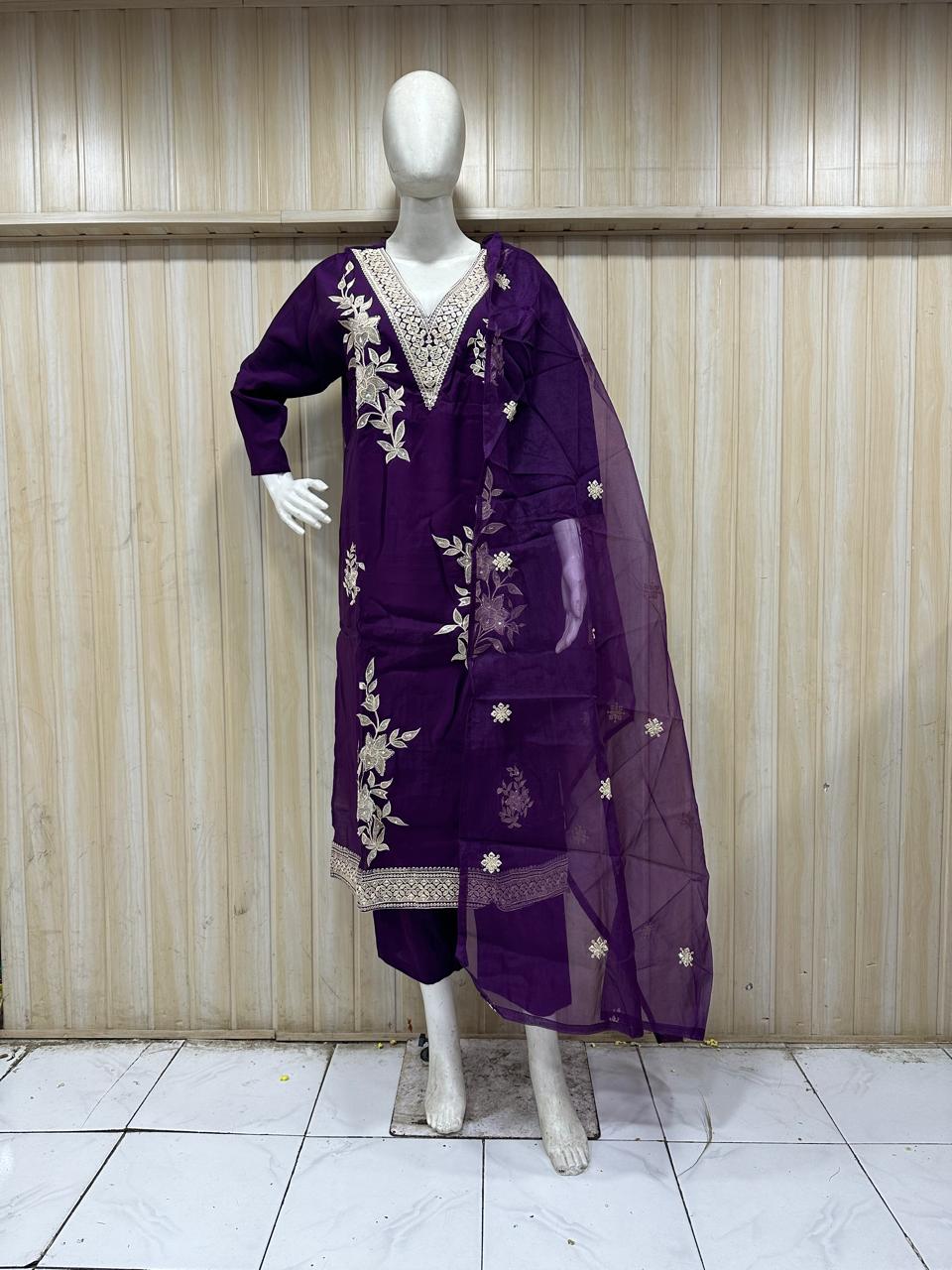 purple embroidered dress with a matching dupatta on a mannequin against a striped