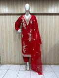 red embroidered dress with a matching dupatta on a mannequin against a striped